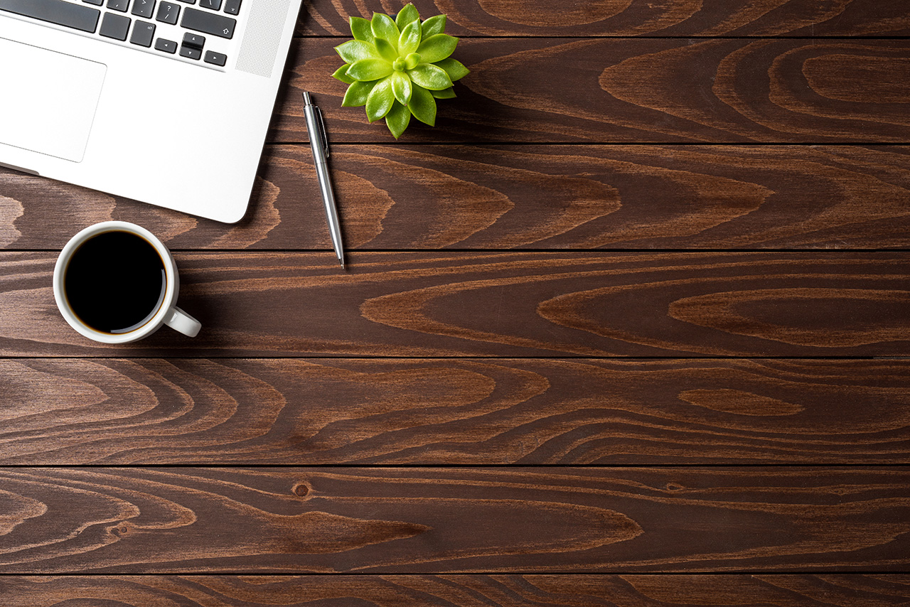 Laptop with office accessories on wooden table